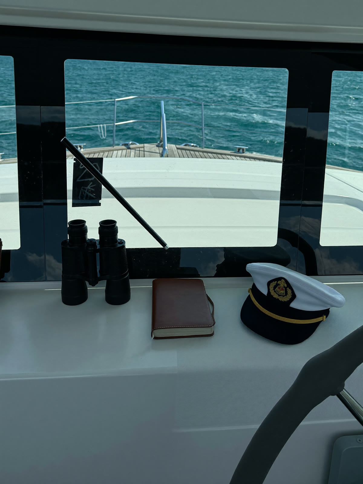 Binoculars, logbook and cap on the bridge console