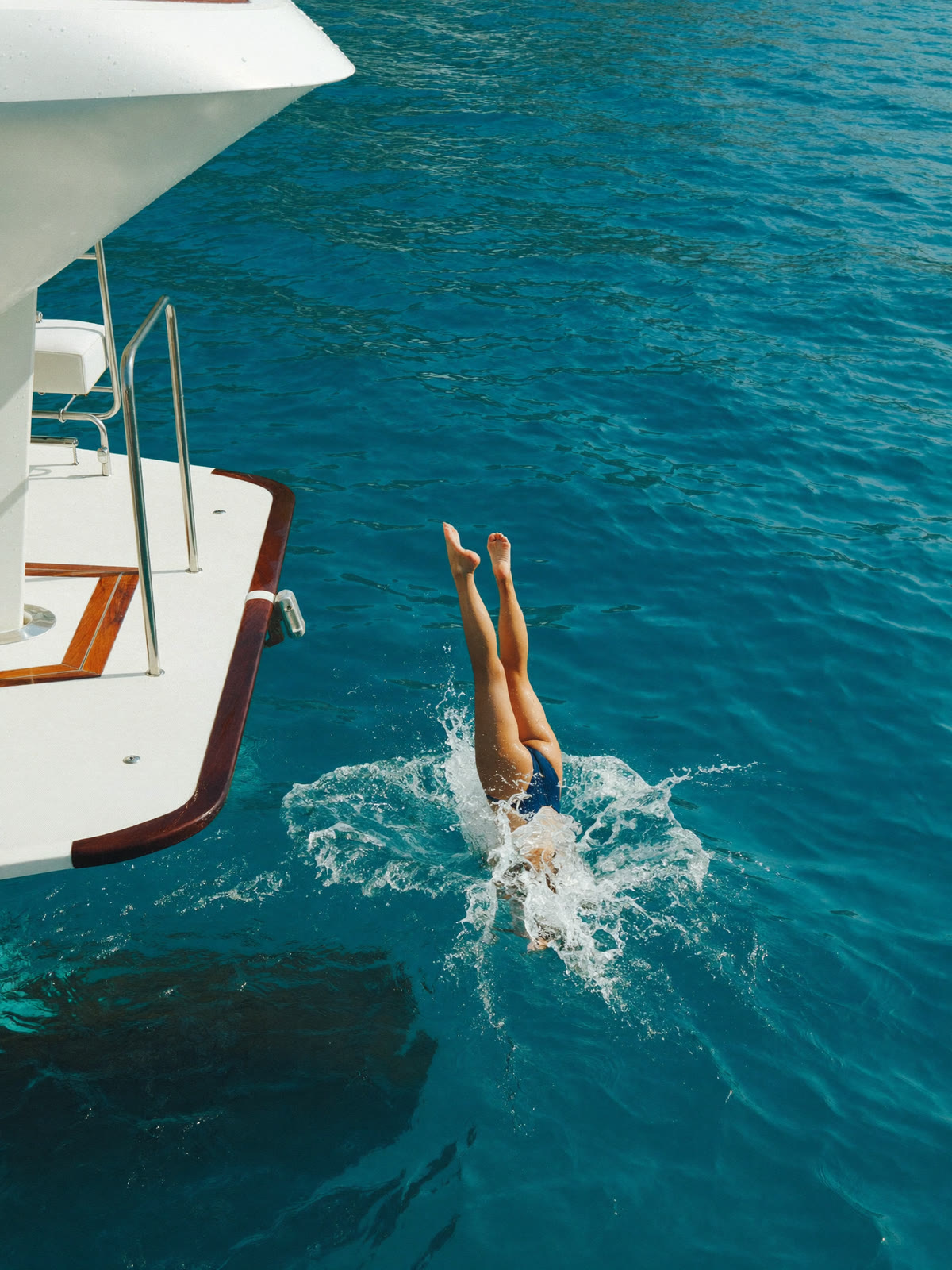 Sprung von der Badeplattform einer Yacht ins türkisfarbene Wasser