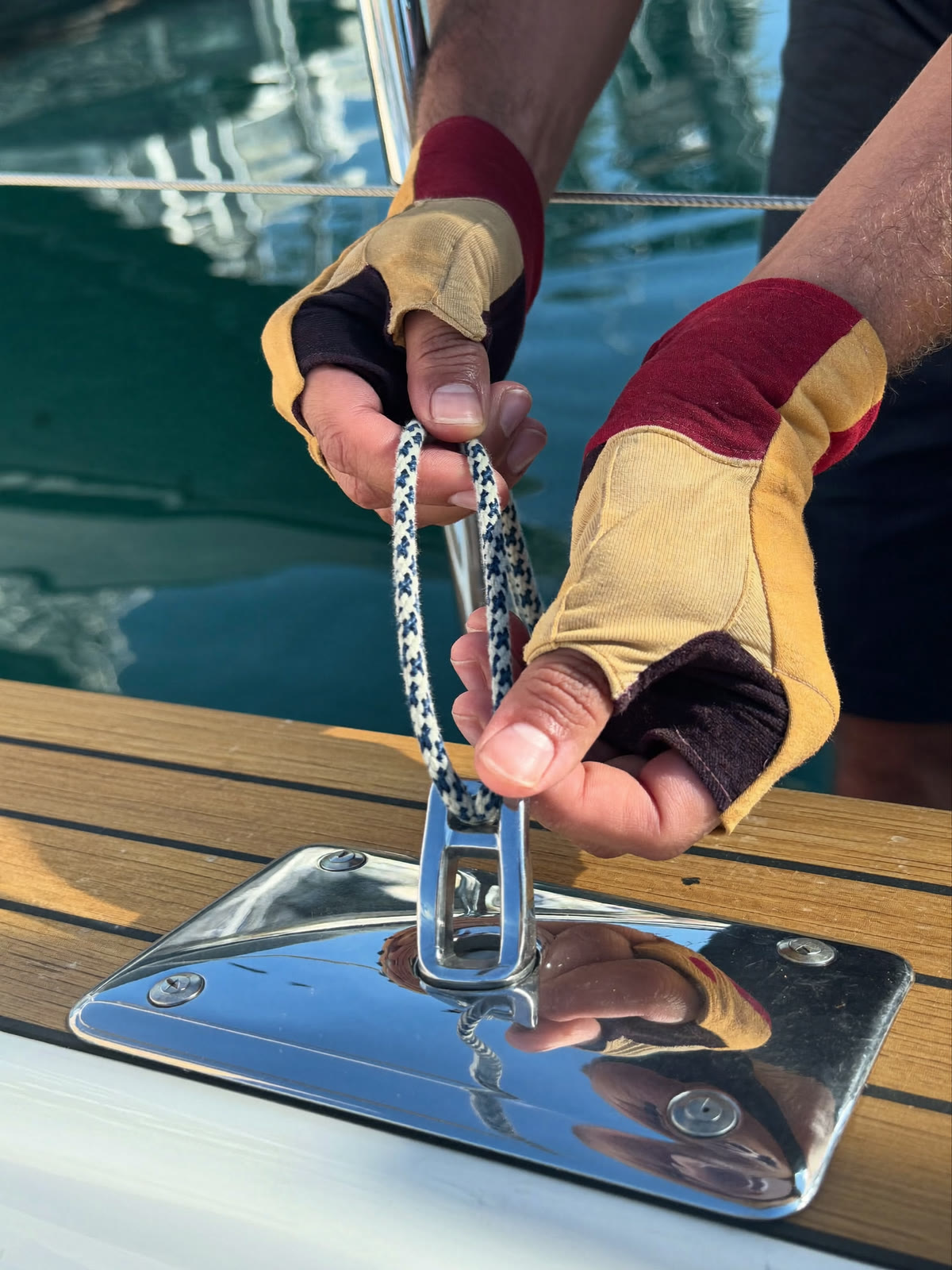 Deckhand’s hands making a line fast on a stainless steel cleat
